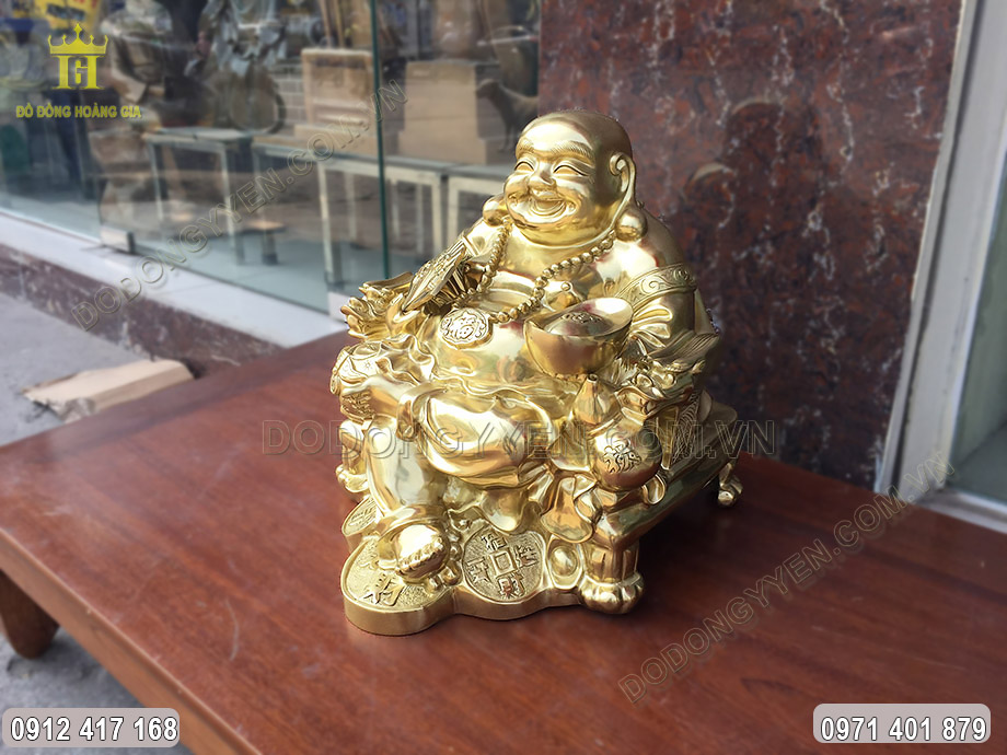 Tượng Phật Di Lặc được chế tác trong tư thế ngồi tay cầm thỏi vàng